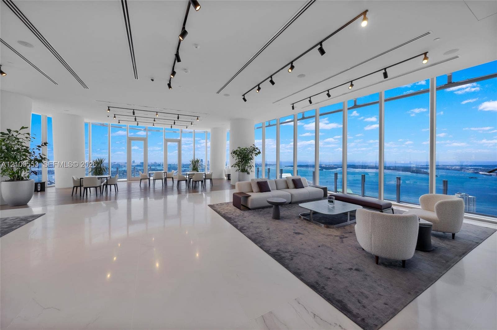 300 Biscayne Boulevard Way, #3002E, Miami, FL 33131 Expansive open-concept floor plan featuring floor-to-ceiling glass walls, polished stone flooring, industrial-style track lighting, and structural columns