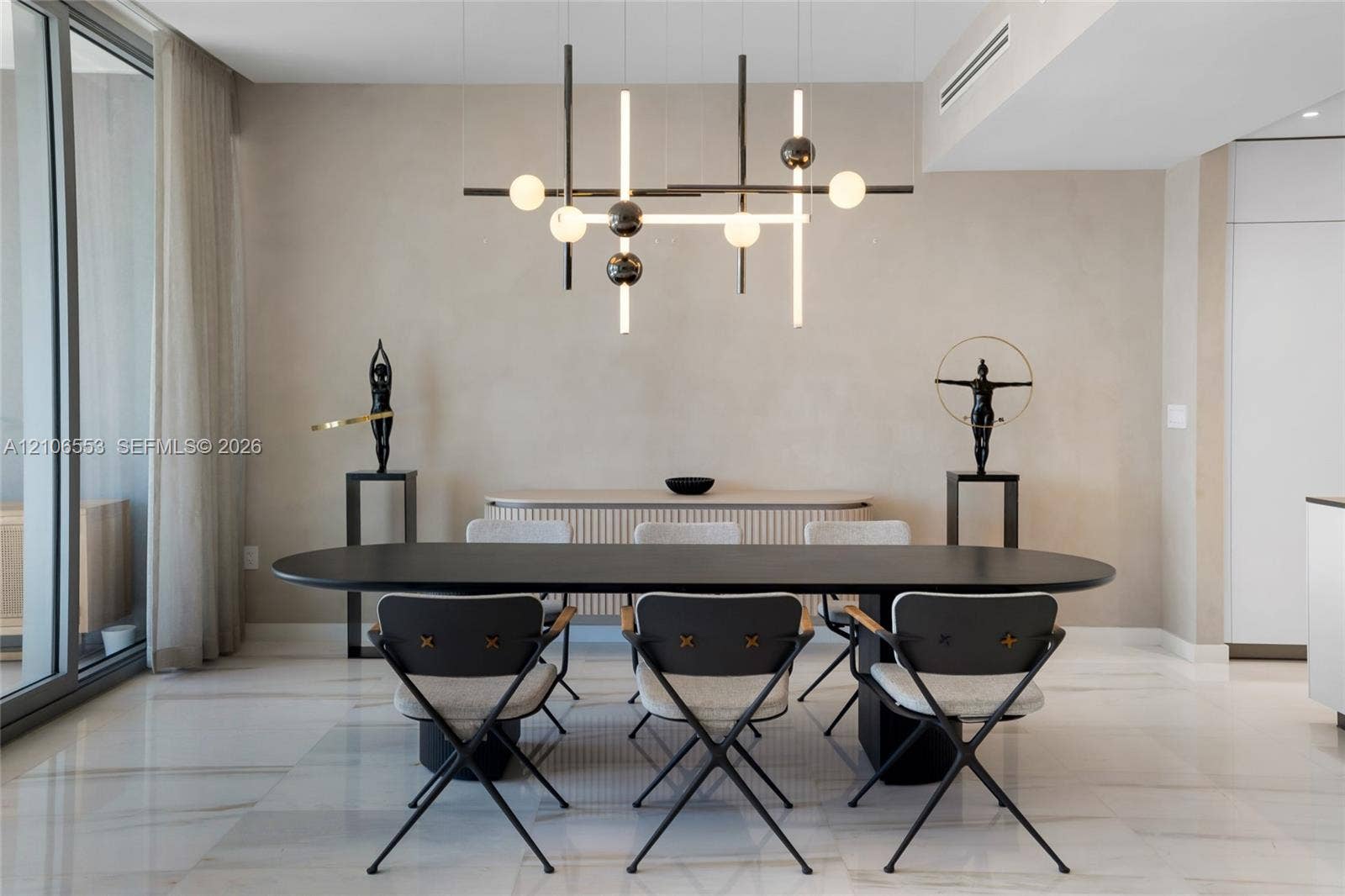 300 Biscayne Boulevard Way, #3002E, Miami, FL 33131 Modern living space featuring large-format stone flooring, floor-to-ceiling glass sliding doors, textured wall finishes, and a linear geometric multi-light chandelier
