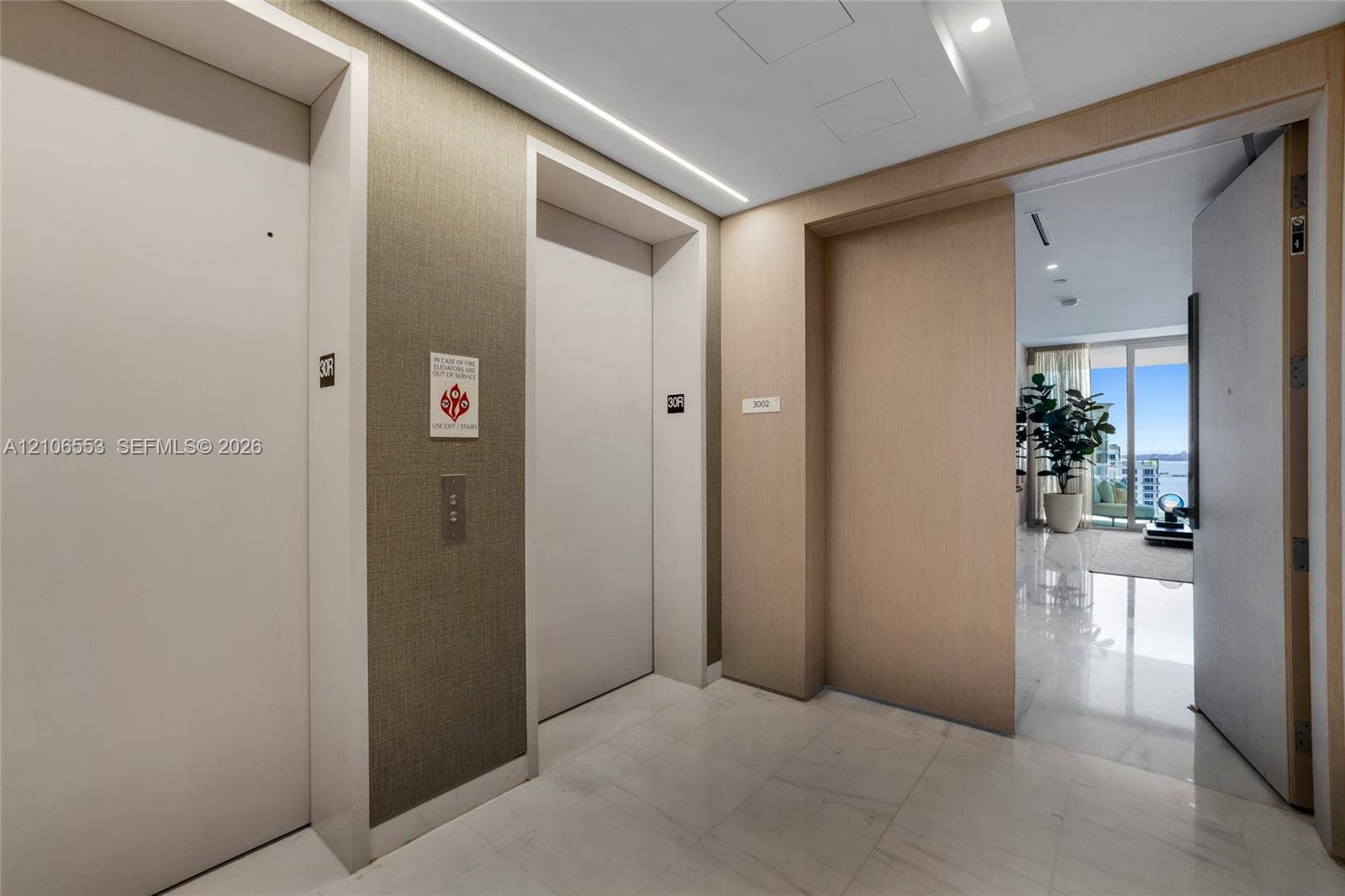 300 Biscayne Boulevard Way, #3002E, Miami, FL 33131 Private elevator landing featuring stone flooring, textured wall coverings, and integrated recessed ceiling lighting