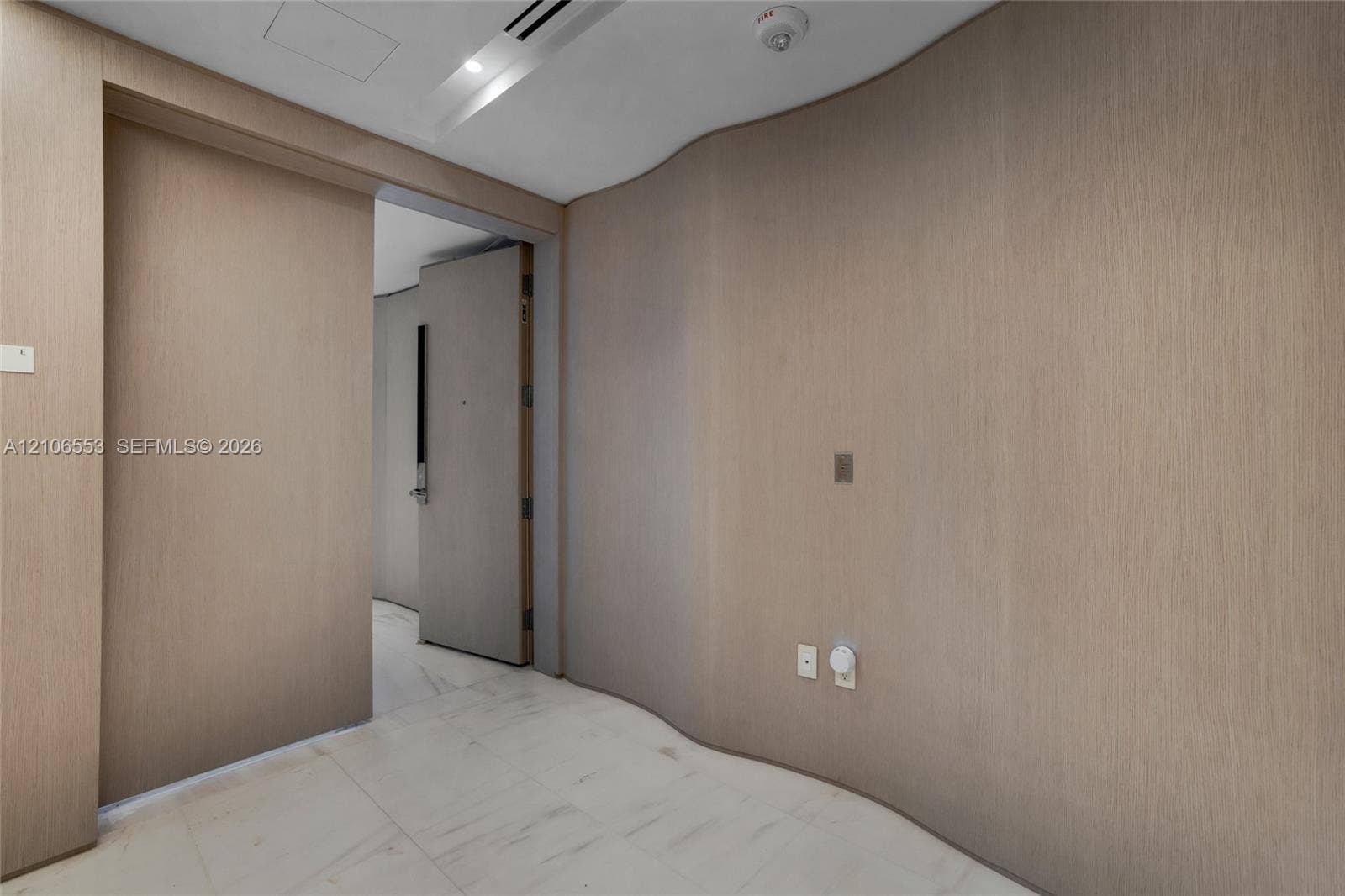 300 Biscayne Boulevard Way, #3002E, Miami, FL 33131 Curved wood-finish wall paneling, full-height sliding door, and stone-finish flooring