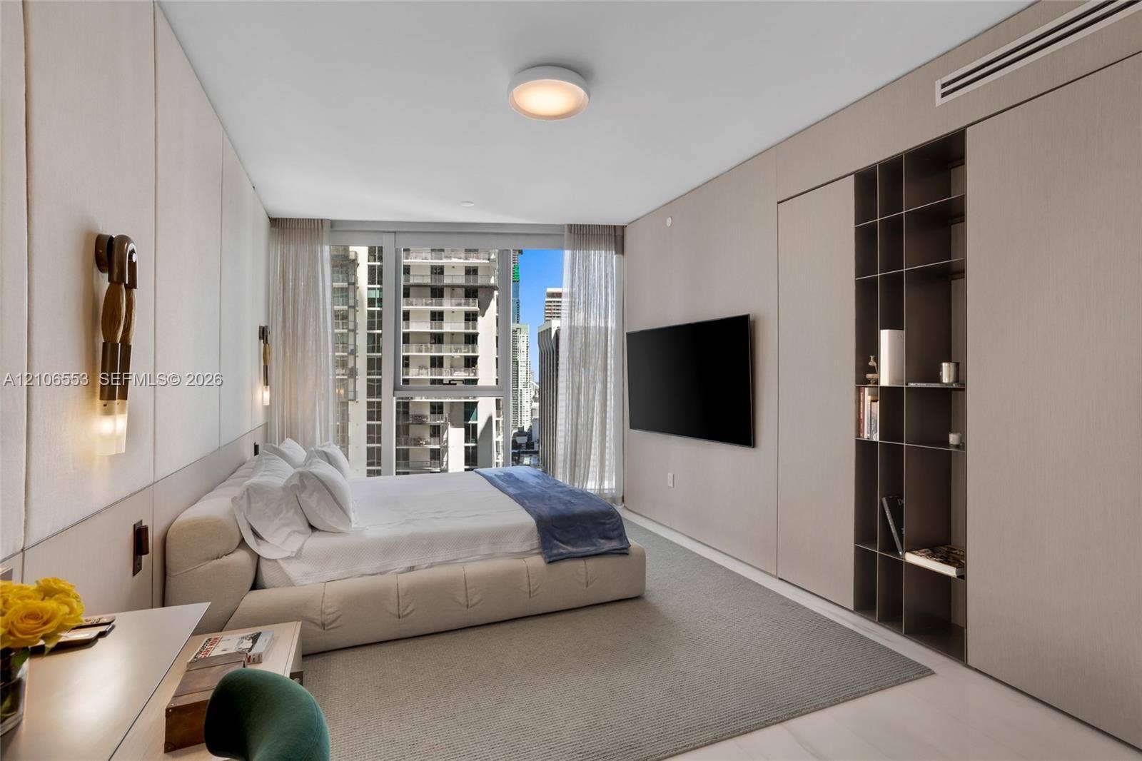 300 Biscayne Boulevard Way, #3002E, Miami, FL 33131 Wall-to-wall integrated cabinetry with open shelving, floor-to-ceiling windows, neutral upholstered wall paneling, and dual contemporary wall-mounted light fixtures