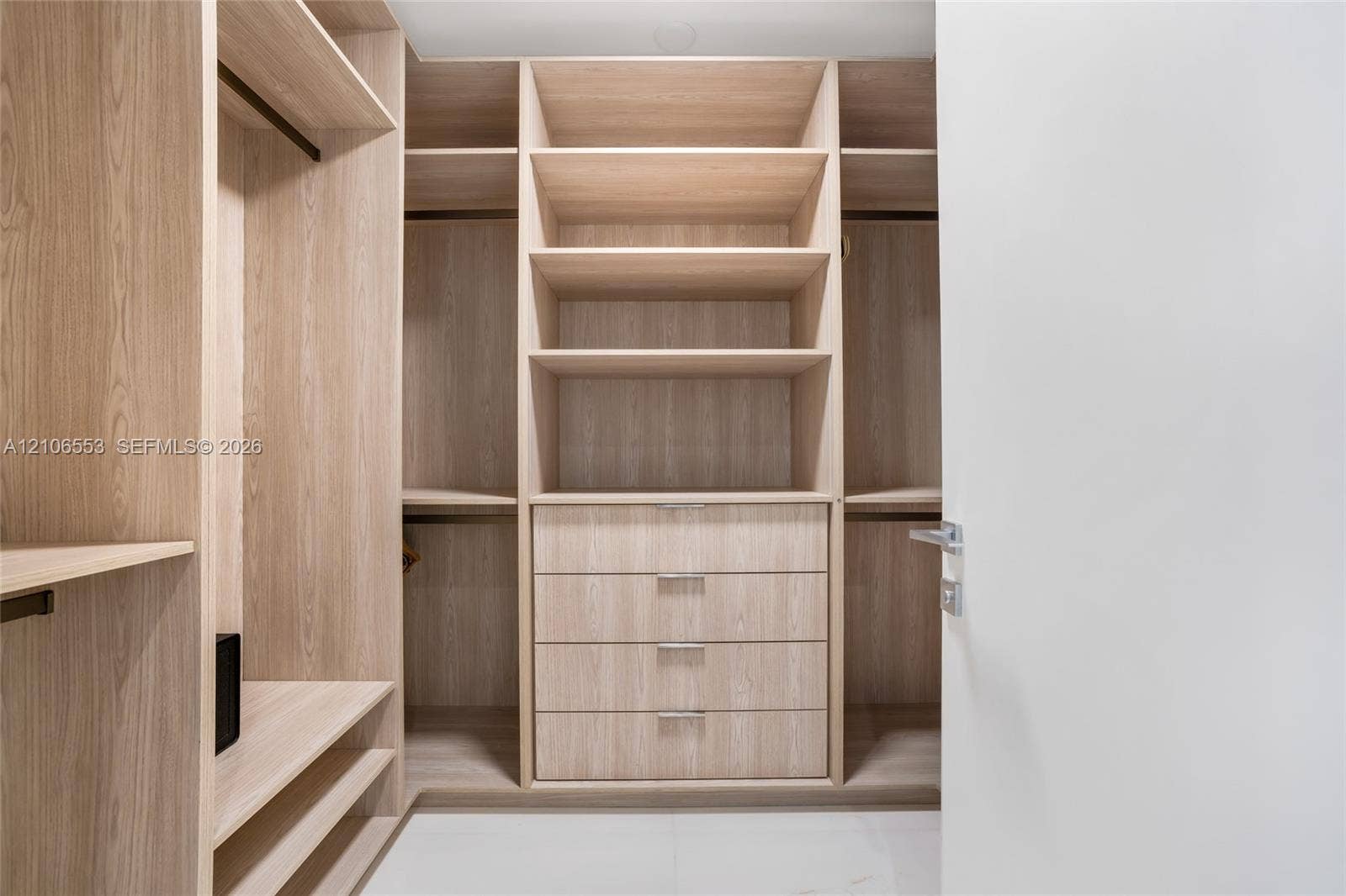 300 Biscayne Boulevard Way, #3002E, Miami, FL 33131 Custom closet organization system featuring light wood-finish cabinetry, built-in shelving, integrated hanging rods, and a four-drawer dresser unit with metallic pulls