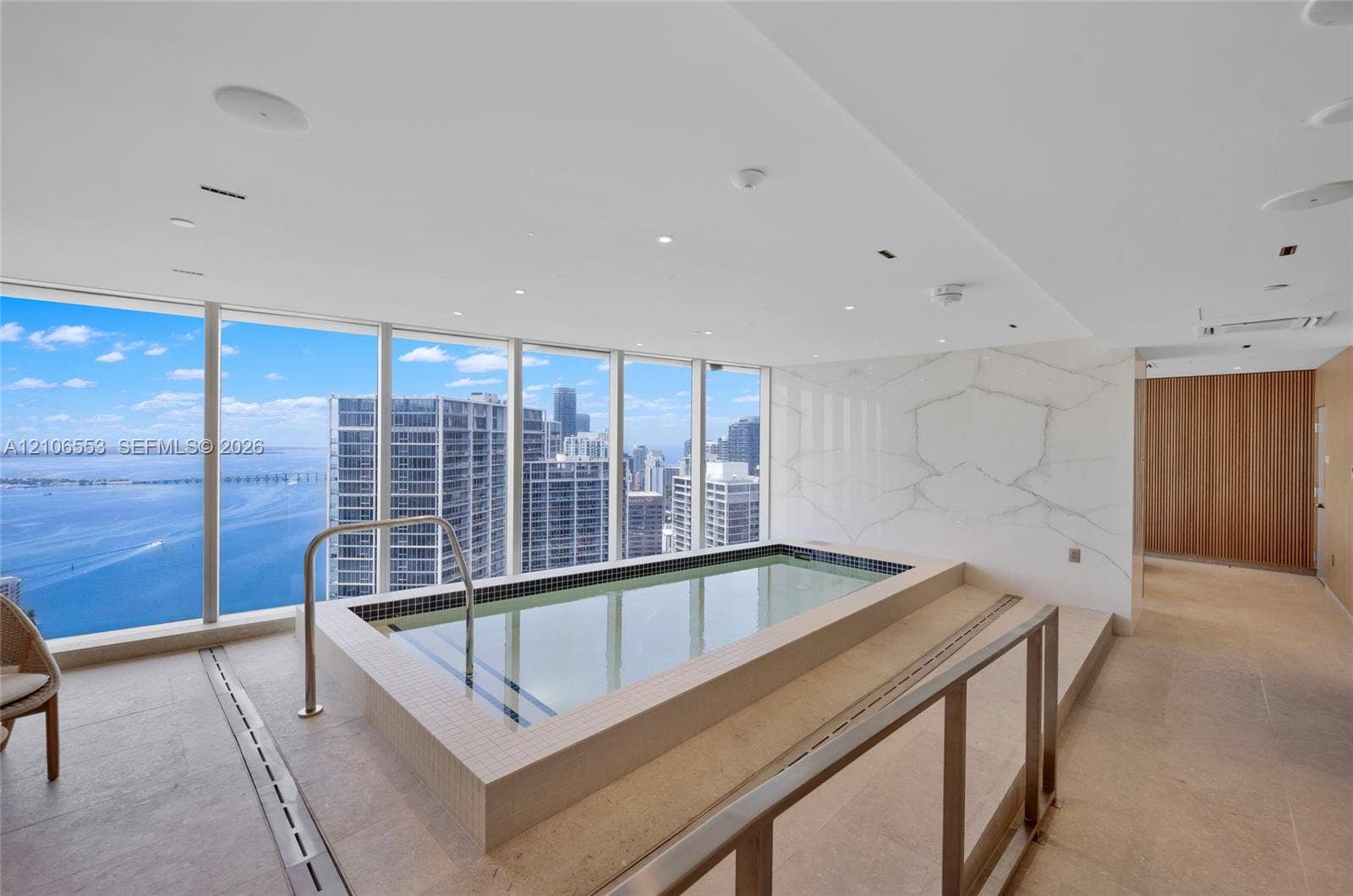 300 Biscayne Boulevard Way, #3002E, Miami, FL 33131 Indoor pool featuring floor-to-ceiling windows, stone-tile flooring, large-format stone wall cladding, and recessed ceiling lighting