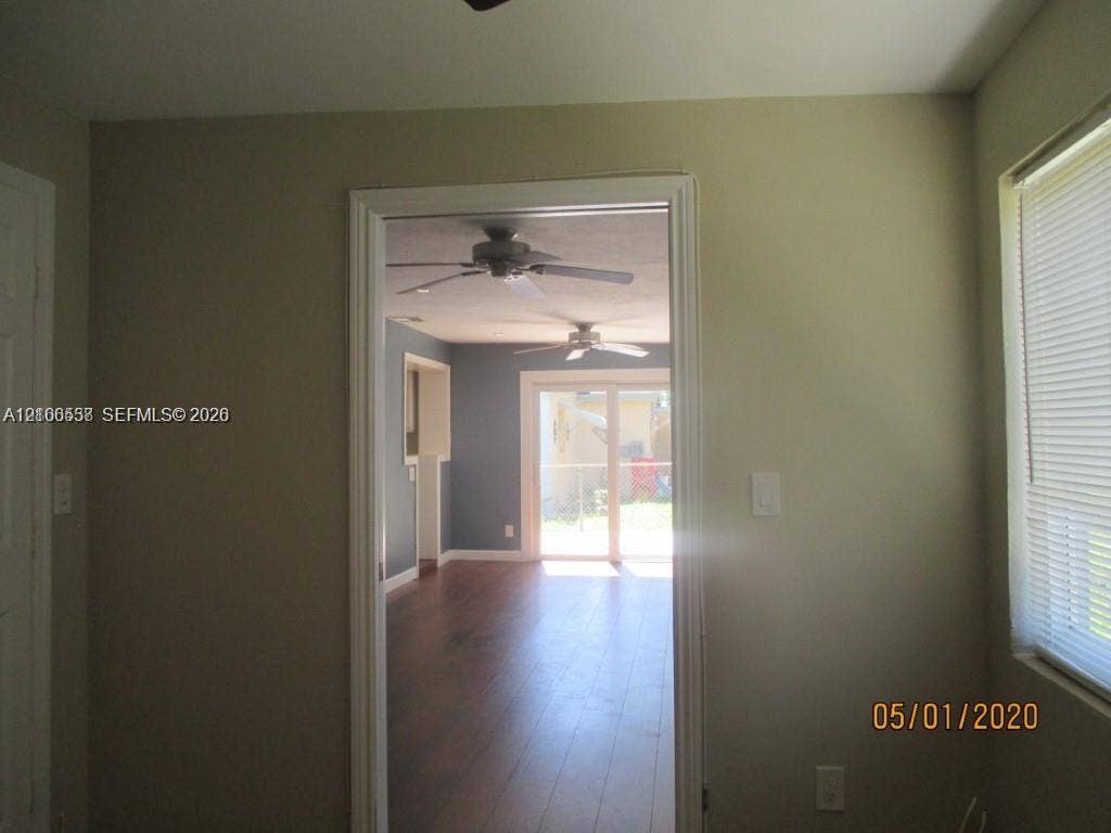 Interior space featuring wood-finish flooring, sliding glass patio doors, and dual ceiling fans
