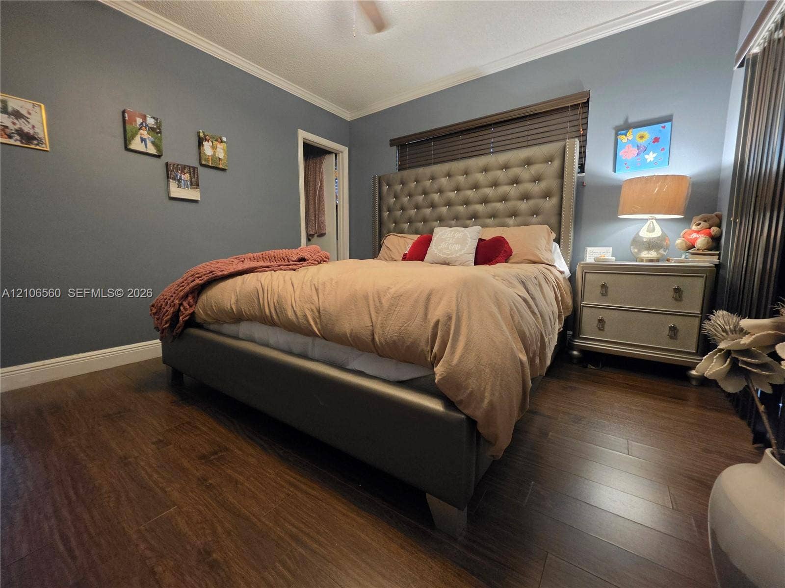 9550 W Elm Lane, Miramar, FL 33025 Bedroom featuring dark wood-finish flooring, crown molding, and horizontal slat window blinds