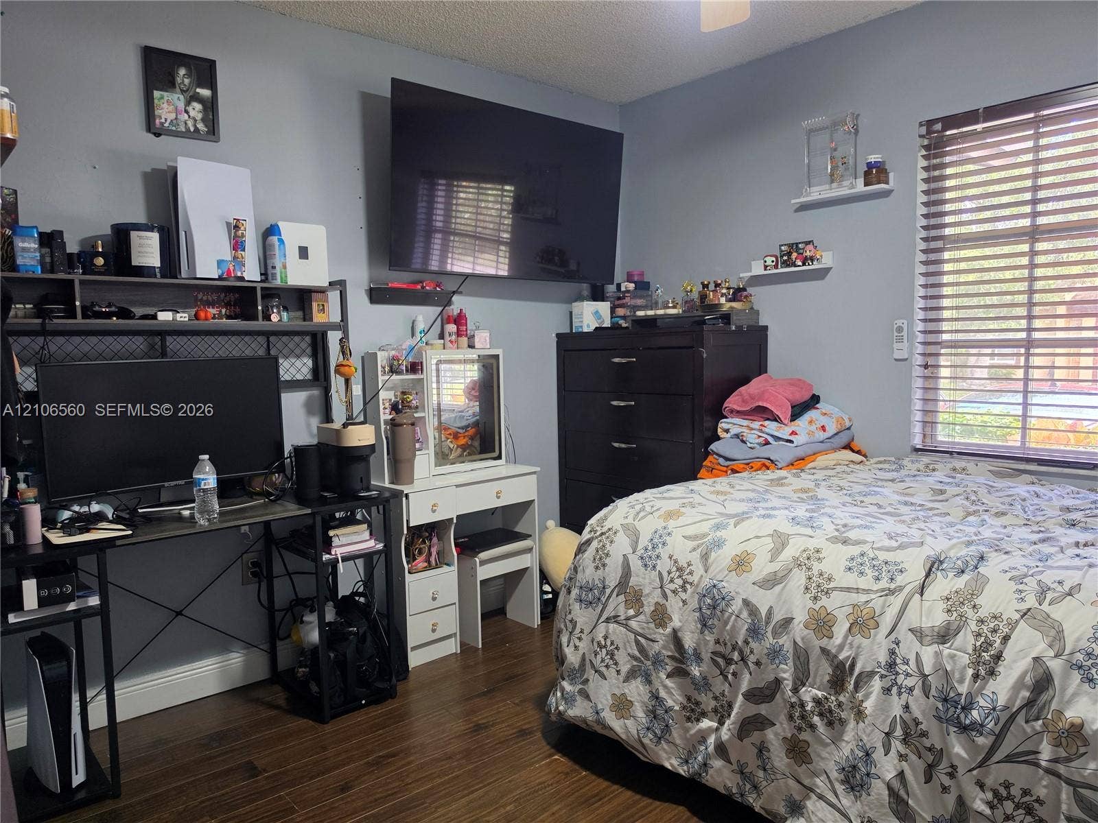 9550 W Elm Lane, Miramar, FL 33025 Wood-finish flooring, horizontal window blinds, and two wall-mounted floating shelves