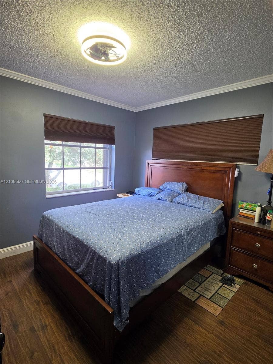 9550 W Elm Lane, Miramar, FL 33025 Wood-finish flooring, crown molding, and a multi-pane window with custom cellular shades
