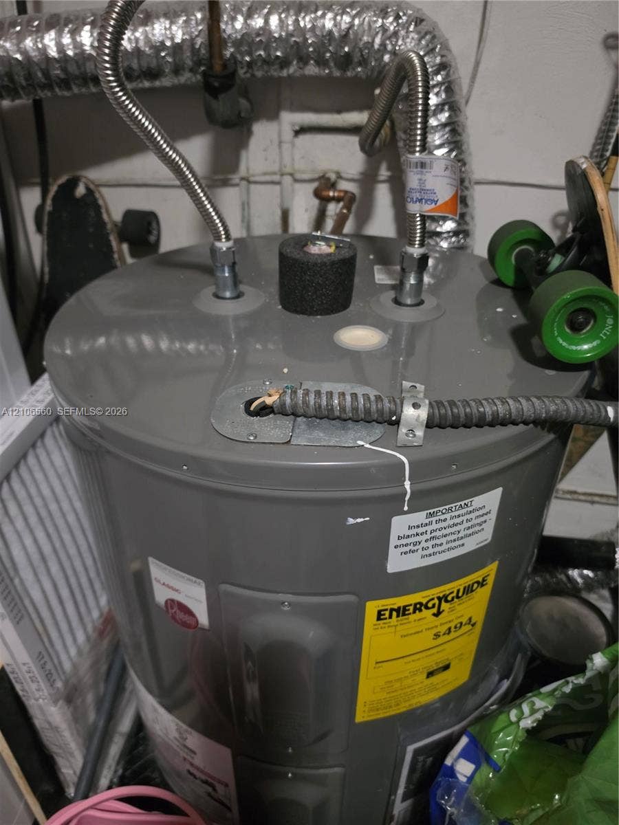 9550 W Elm Lane, Miramar, FL 33025 Electric water heater featuring braided metal supply lines, a protective insulation cap, and a metal-clad electrical conduit