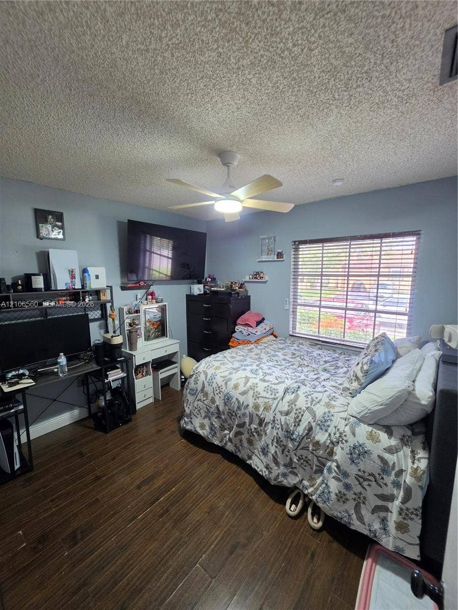 9550 W Elm Lane, Miramar, FL 33025 Room featuring wood-finish flooring, a ceiling fan with integrated light, and a window with horizontal blinds