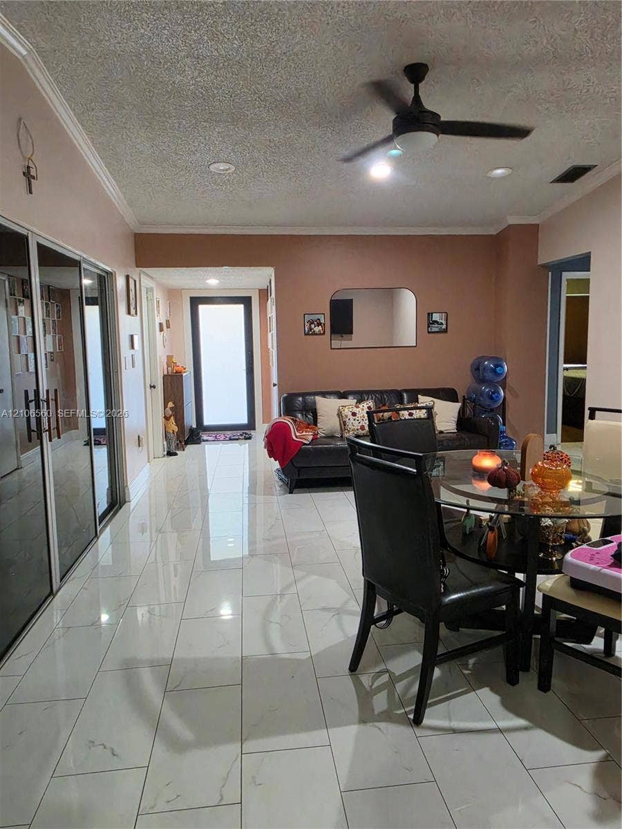 9550 W Elm Lane, Miramar, FL 33025 Large-format white tile flooring, ceiling fan with integrated lighting, recessed lighting, and expansive mirrored closet doors
