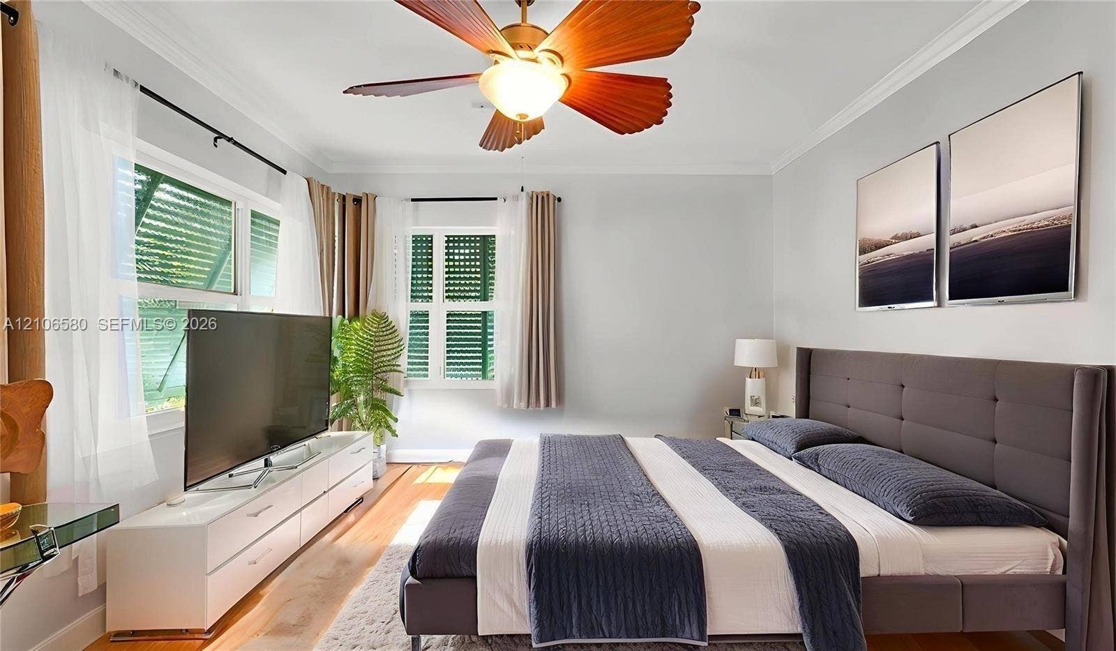 623 NE 17th Way, Fort Lauderdale, Fort Lauderdale, FL 33304 Wood-finish flooring, multi-blade ceiling fan with integrated lighting, crown molding, and windows featuring plantation-style shutters