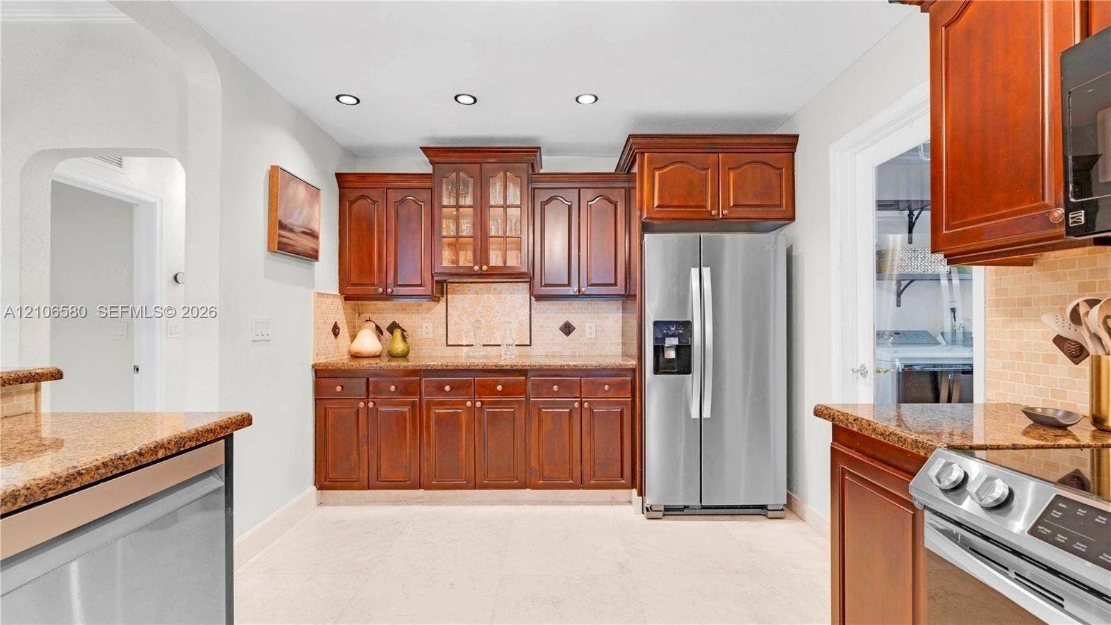 623 NE 17th Way, Fort Lauderdale, Fort Lauderdale, FL 33304 Kitchen featuring rich wood cabinetry, stone countertops, tiled backsplash, stainless steel appliances, and recessed lighting