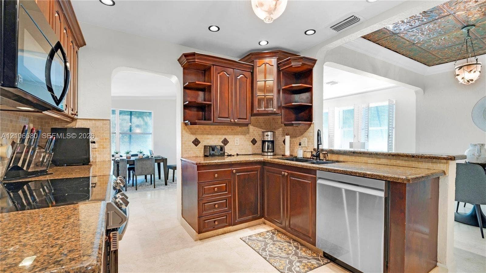 623 NE 17th Way, Fort Lauderdale, Fort Lauderdale, FL 33304 Kitchen featuring stained wood cabinetry, stone countertops, stone tile backsplash, recessed lighting, and a decorative ceiling inlay