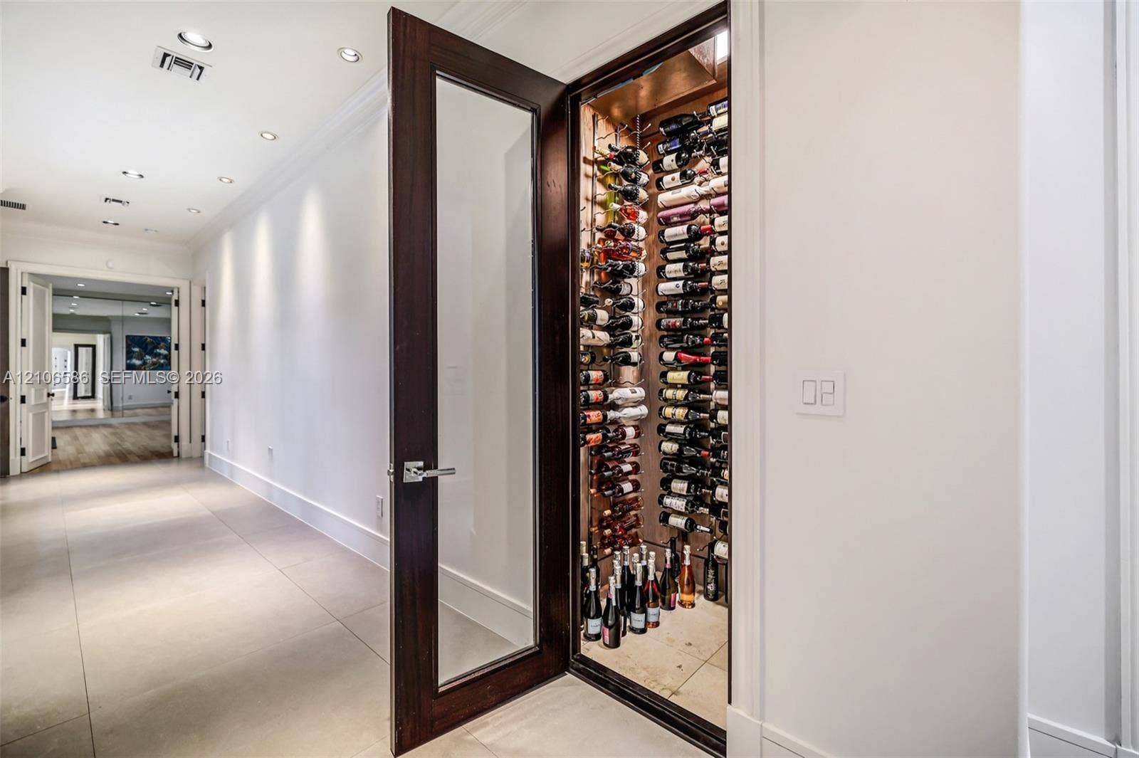 9325 SW 59th Place, Pinecrest, FL 33156 300-bottle, climate-controlled wine storage featuring a wood-finish door with glass inset, structured metal racking, and recessed interior lighting