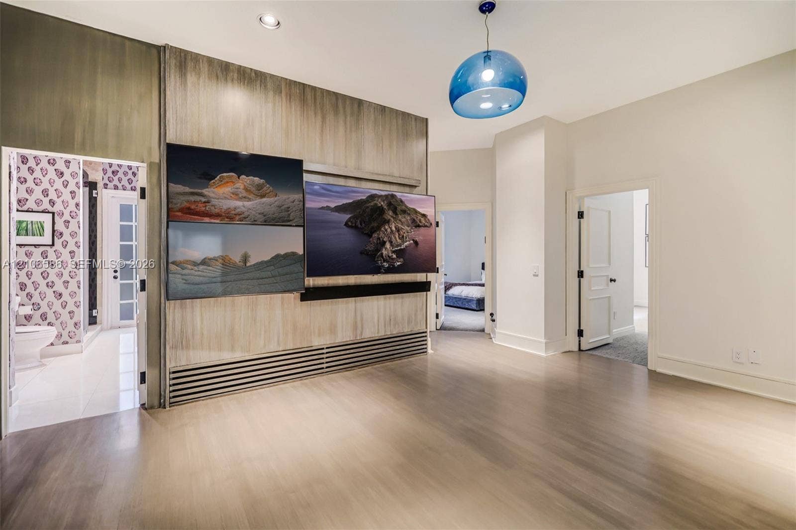 9325 SW 59th Place, Pinecrest, FL 33156 Wood-finish wall paneling with integrated media station, recessed ceiling lighting, and blue glass pendant fixture