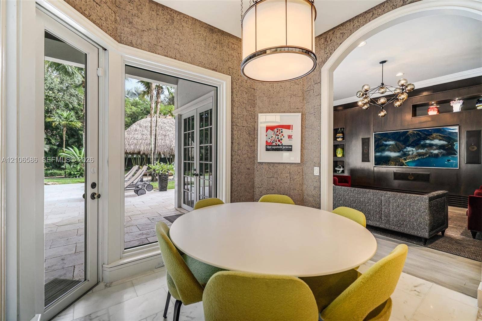 9325 SW 59th Place, Pinecrest, FL 33156 Dining area featuring textured wall coverings, stone-finish flooring, a contemporary drum pendant light, and French doors opening to an exterior patio