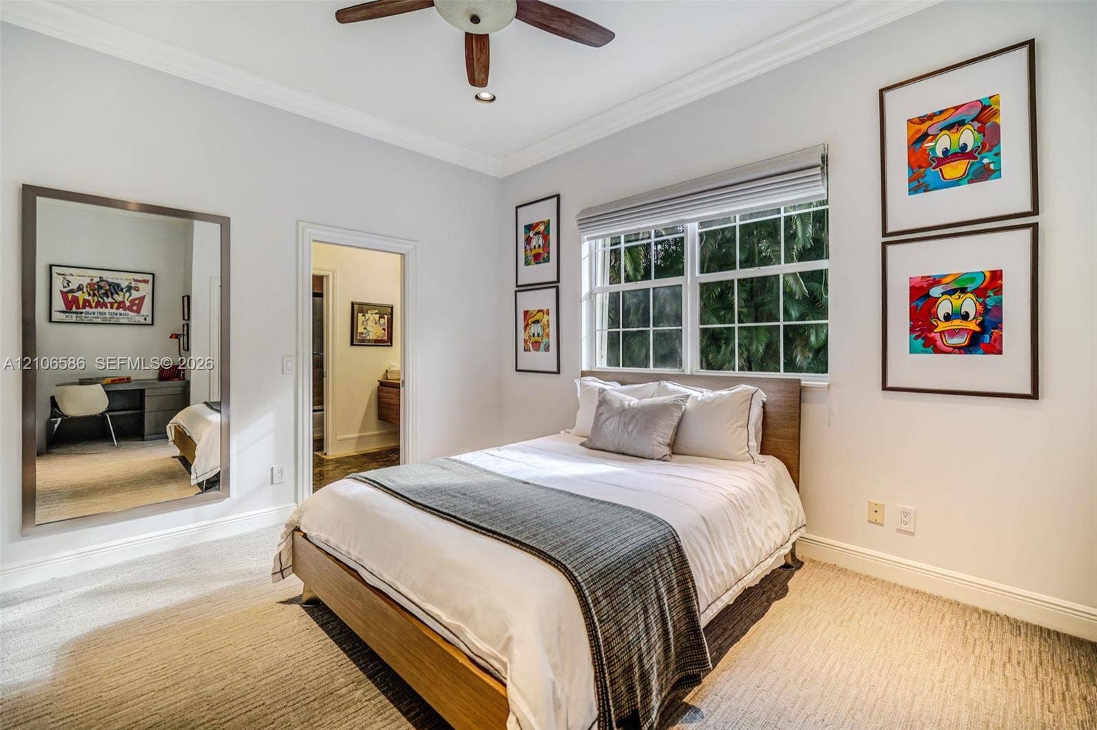 9325 SW 59th Place, Pinecrest, FL 33156 Room featuring neutral carpeting, crown molding, multi-pane window with custom blinds, ceiling fan, and a large wall-mounted mirror