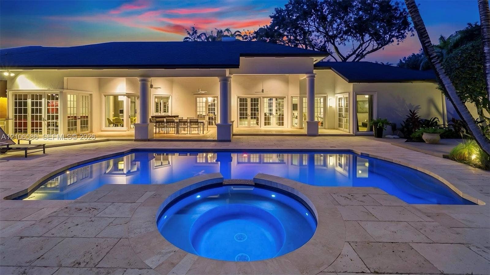 9325 SW 59th Place, Pinecrest, FL 33156 Covered patio featuring structural columns, inground pool, integrated spa, and stone-paver decking