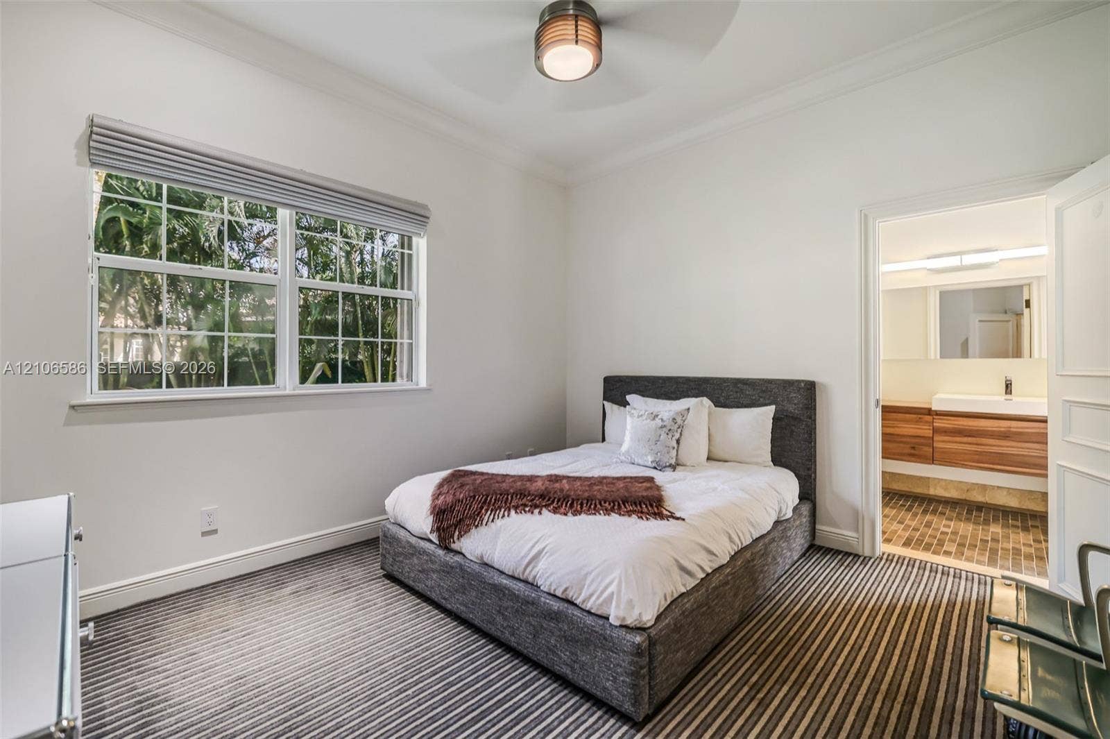 9325 SW 59th Place, Pinecrest, FL 33156 Neutral-toned room featuring a multi-pane window, wall-to-wall striped carpeting, and a ceiling-mounted light fixture