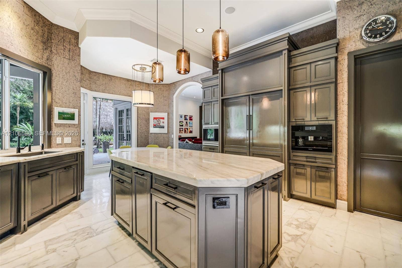 9325 SW 59th Place, Pinecrest, FL 33156 Custom cabinetry with panel-ready integrated appliances, expansive stone-topped central island, polished stone flooring, and multi-pendant lighting