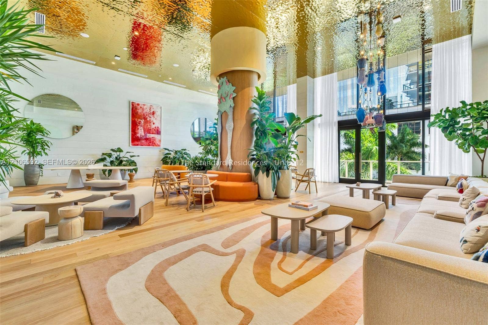 90 NE 32, #612, Miami, Miami, FL 33127 Reflective metallic ceiling, floor-to-ceiling windows, wood-finish flooring, central structural column, and custom decorative lighting fixture