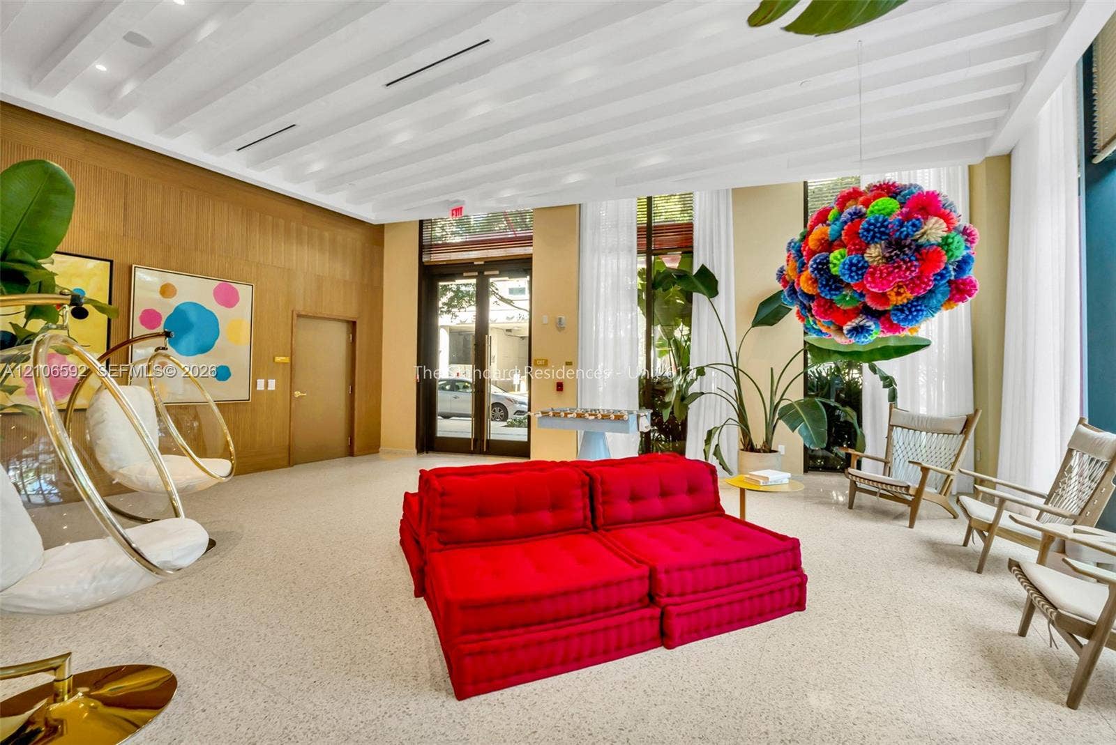 90 NE 32, #612, Miami, Miami, FL 33127 High-ceiling lobby featuring expansive floor-to-ceiling windows, light-toned terrazzo flooring, and natural wood-paneled walls