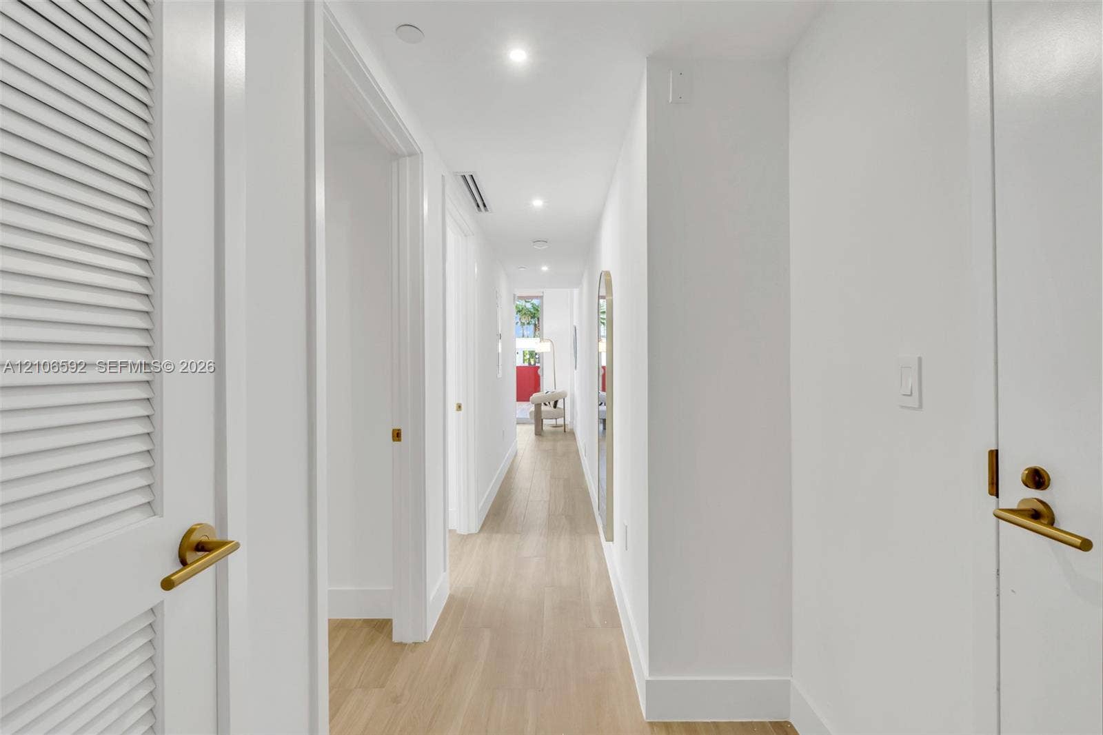 90 NE 32, #612, Miami, Miami, FL 33127 Hallway featuring wood-finish flooring, recessed lighting, and doors with gold-tone hardware, including a louvered closet door