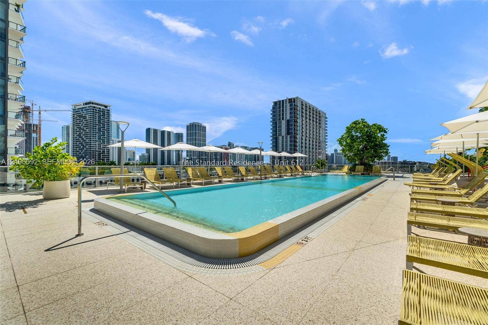 90 NE 32, #612, Miami, Miami, FL 33127 Rooftop swimming pool featuring a tiled perimeter, integrated drainage, glass panel railings, and expansive paved deck surfacing