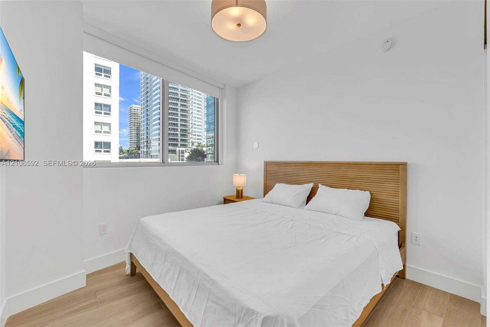90 NE 32, #612, Miami, Miami, FL 33127 Large windows, light wood-finish flooring, and a contemporary drum-style ceiling light fixture