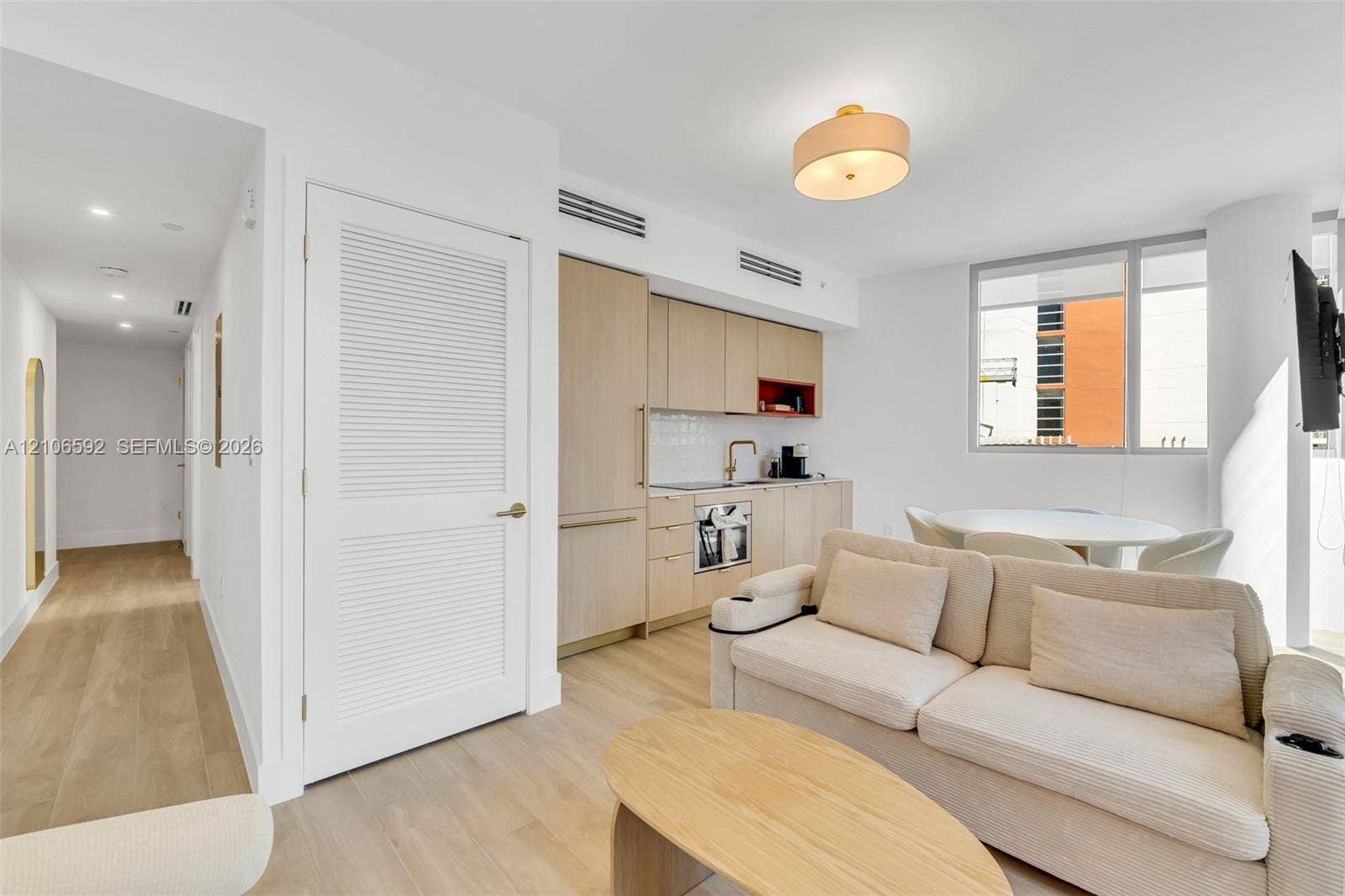 90 NE 32, #612, Miami, Miami, FL 33127 Light-toned cabinetry, wood-finish flooring, built-in panel-ready appliances, louvered closet door, and drum ceiling lighting