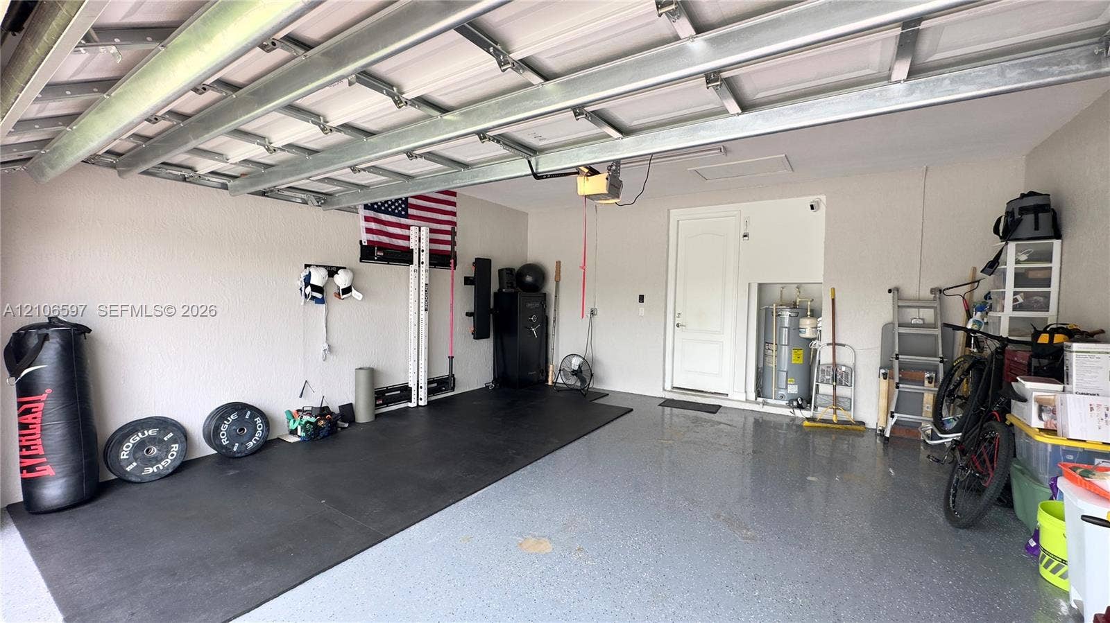 Finished garage featuring an epoxy-coated floor, automatic overhead door, and direct interior access door