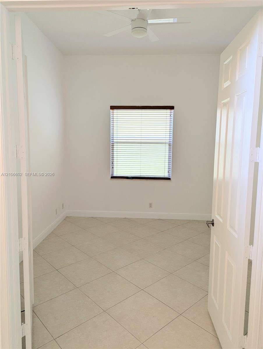 15274 Fiorenza Circle, Delray Beach, FL 33446 Neutral interior space featuring diagonal-set tile flooring, a ceiling fan, and a window with horizontal blinds