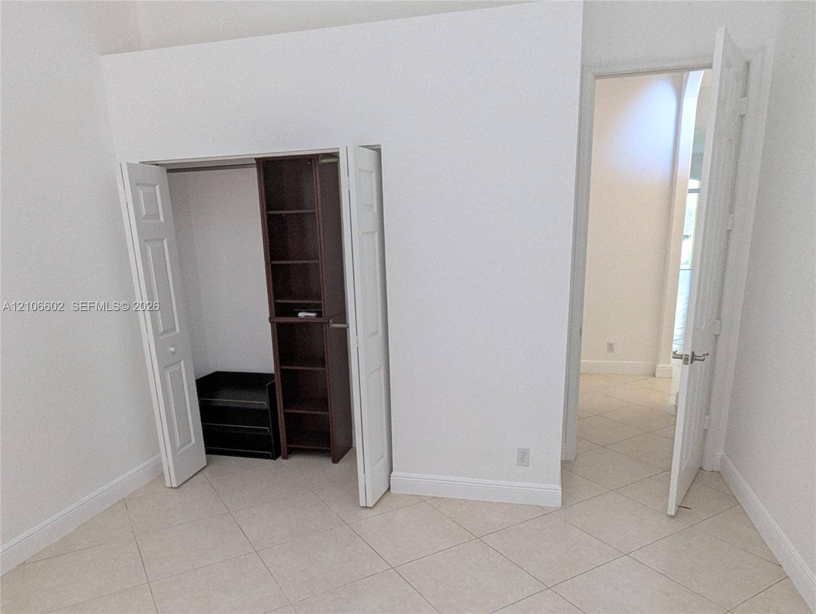 15274 Fiorenza Circle, Delray Beach, FL 33446 Neutral-toned tile flooring, closet featuring built-in shelving, and six-panel interior doors