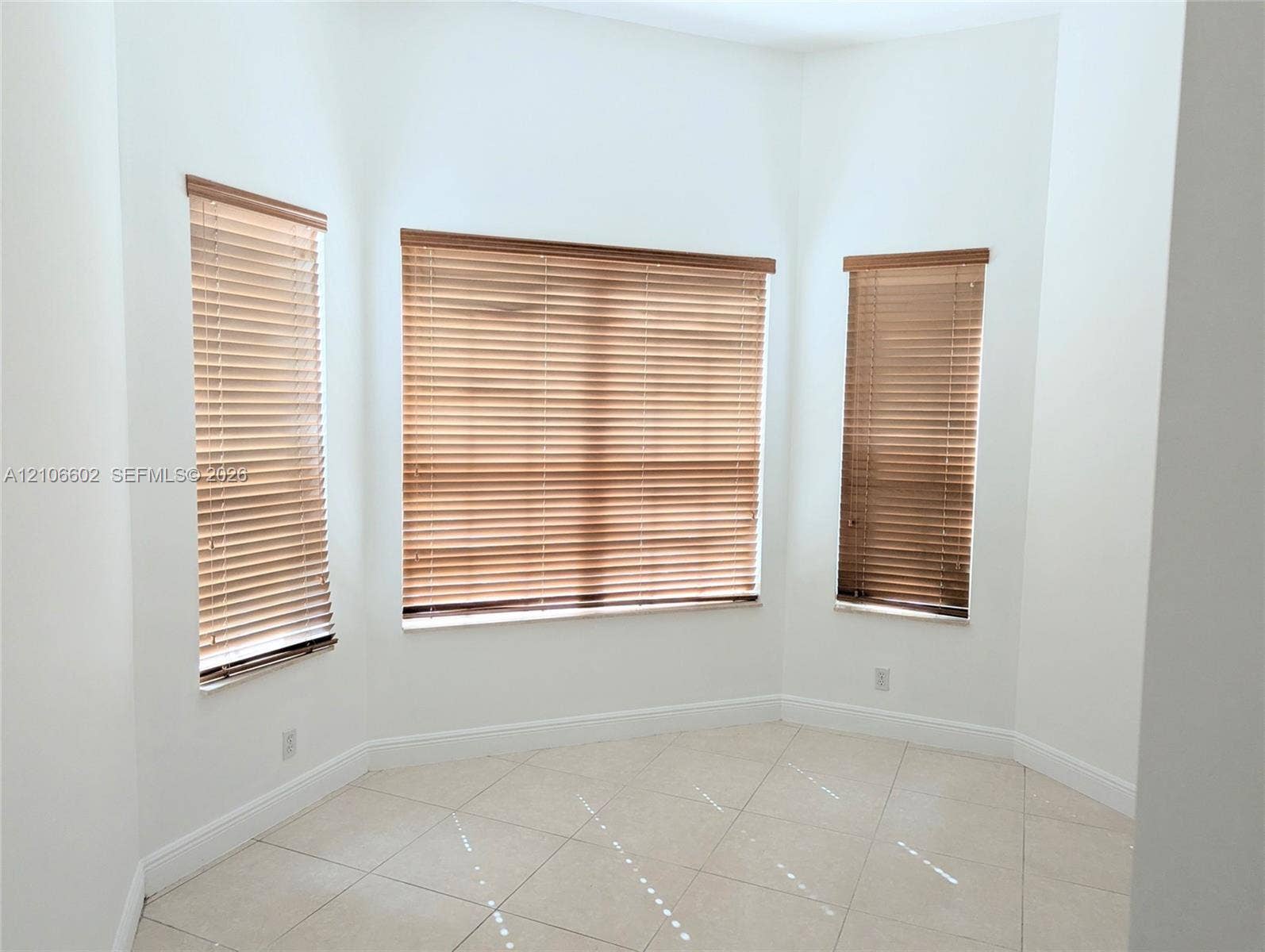 15274 Fiorenza Circle, Delray Beach, FL 33446 Bay window with three rectangular windows, neutral-tone tile flooring, and installed horizontal blinds