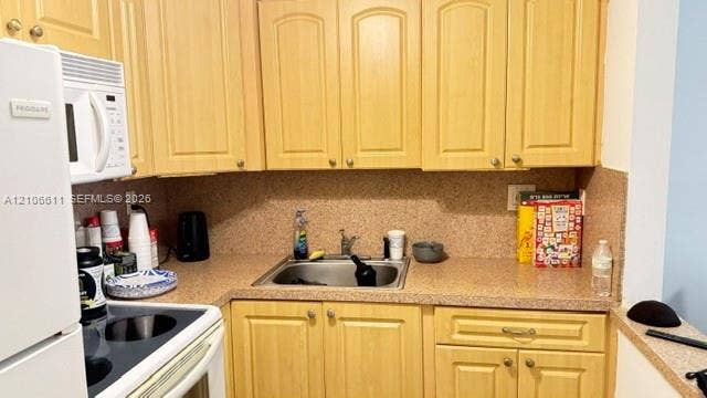 17570 Atlantic Boulevard, #105, Sunny Isles Beach, Sunny Isles Beach, FL 33160 Kitchen featuring light-tone wood cabinetry, solid-surface countertops, a stainless steel undermount sink with a gooseneck faucet, and an integrated white microwave