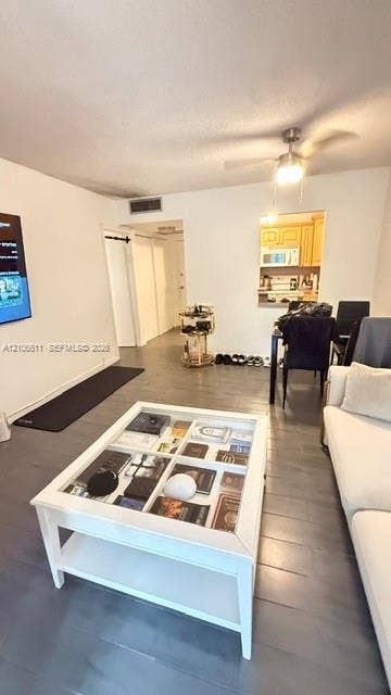 17570 Atlantic Boulevard, #105, Sunny Isles Beach, Sunny Isles Beach, FL 33160 Neutral-toned tile flooring, ceiling-mounted fan with integrated lighting, and built-in wall pass-through to kitchen cabinetry