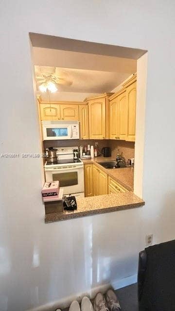 17570 Atlantic Boulevard, #105, Sunny Isles Beach, Sunny Isles Beach, FL 33160 Kitchen featuring wood cabinetry, stone-finish countertops, built-in microwave, integrated range, and an open pass-through window