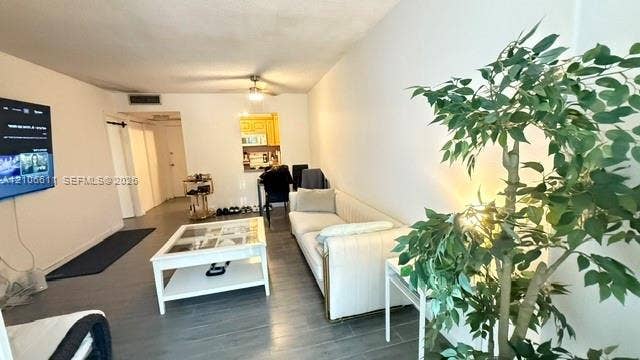 17570 Atlantic Boulevard, #105, Sunny Isles Beach, Sunny Isles Beach, FL 33160 Living area featuring wood-finish flooring, recessed lighting, and a pass-through window opening to a secondary space