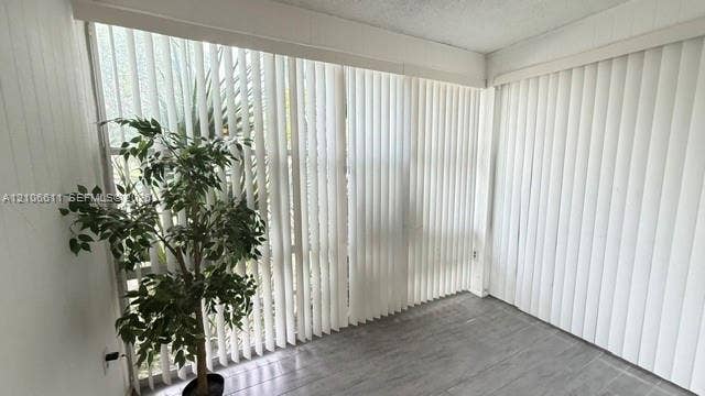 17570 Atlantic Boulevard, #105, Sunny Isles Beach, Sunny Isles Beach, FL 33160 Floor-to-ceiling windows featuring vertical blinds and grey wood-finish flooring
