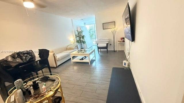 17570 Atlantic Boulevard, #105, Sunny Isles Beach, Sunny Isles Beach, FL 33160 Interior space featuring neutral wall tones, grey tile flooring, a ceiling-mounted light fixture, and a large sliding glass door