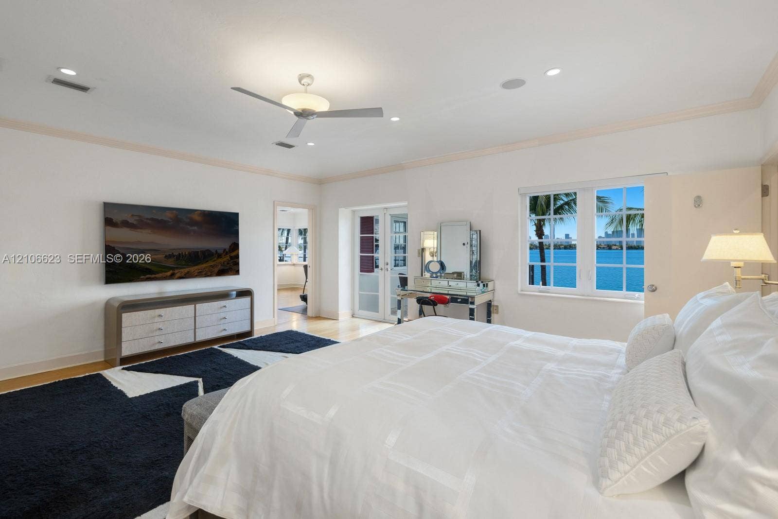 2312 Bay Avenue, Miami Beach, FL 33140 Spacious room featuring crown molding, recessed lighting, a modern ceiling fan, and multipane windows showcasing water