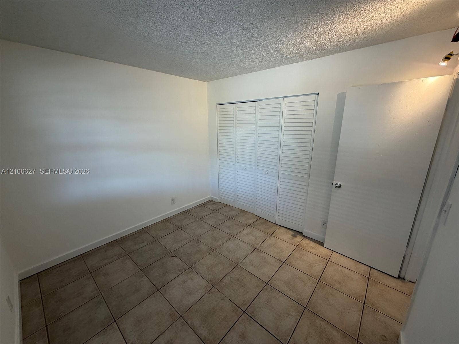 9954 Twin Lakes Drive, #7-O, Coral Springs, Coral Springs, FL 33071 Square tile flooring and built-in closet with white louvered doors