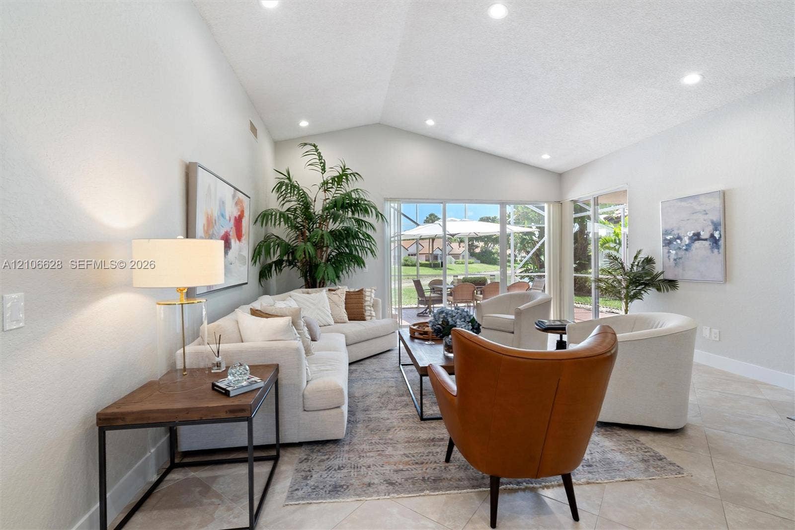 7259 Via Palomar, Boca Raton, FL 33433 Vaulted ceilings with recessed lighting, tile flooring, and oversized glass sliding doors opening to a screened outdoor area