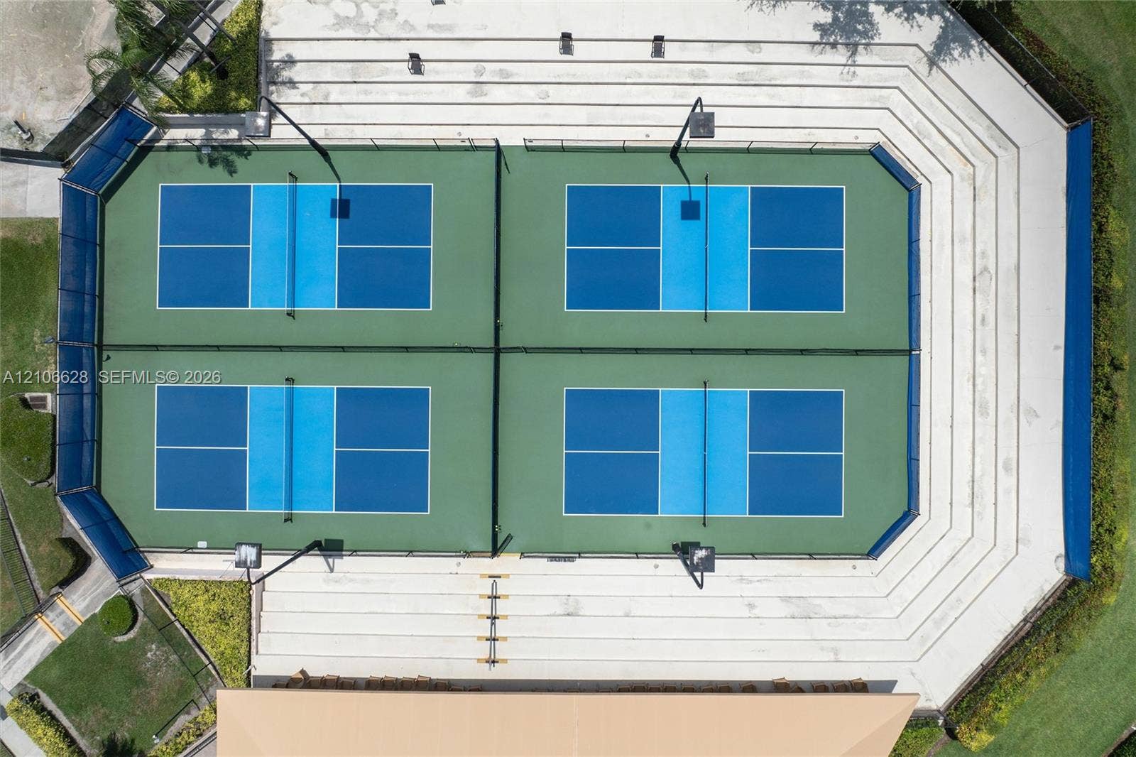 7259 Via Palomar, Boca Raton, FL 33433 Four pickleball courts with perimeter fencing, integrated lighting, and terraced concrete spectator seating