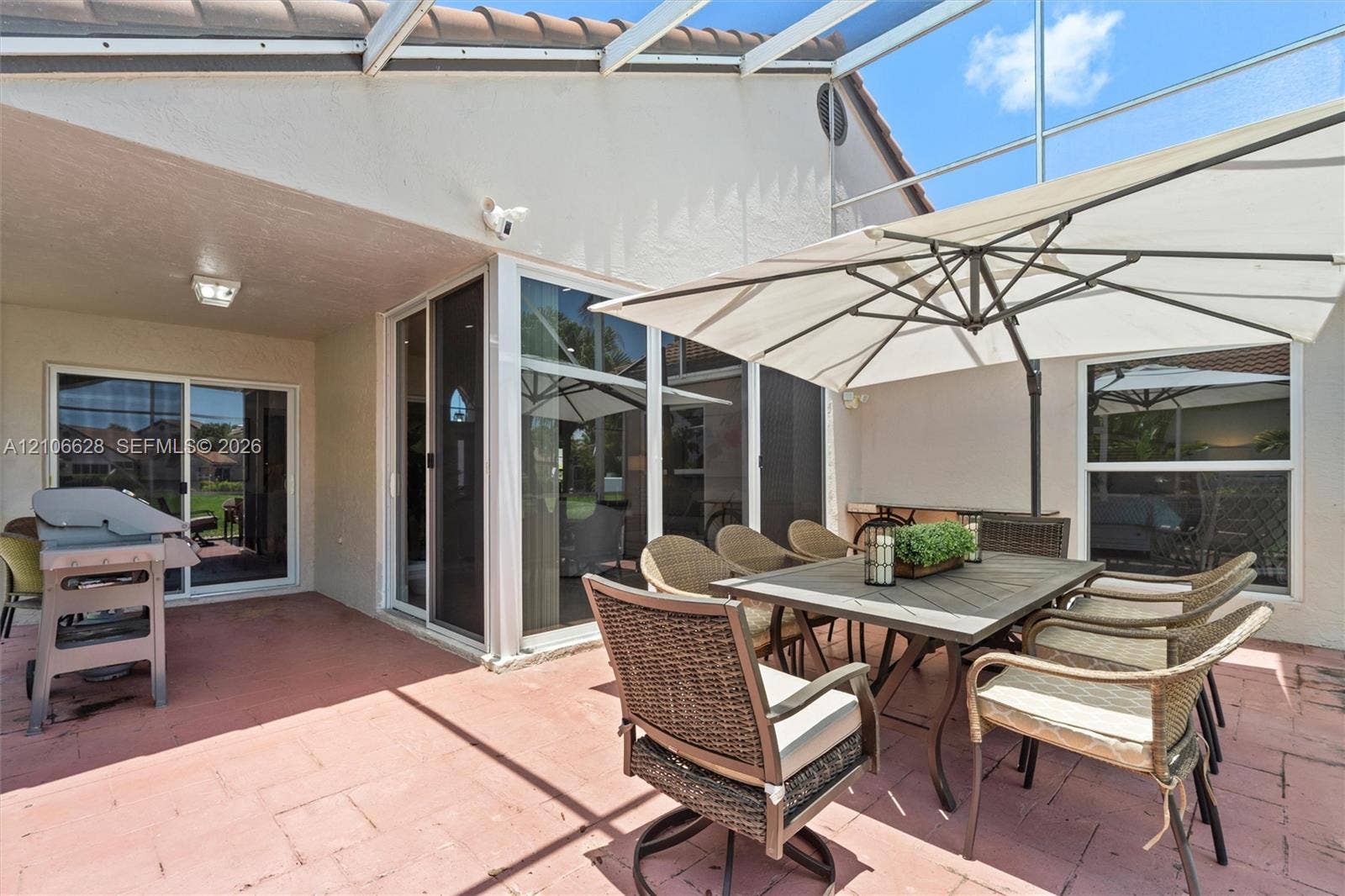 7259 Via Palomar, Boca Raton, FL 33433 Screen-enclosed patio featuring masonry tile flooring, sliding glass door access, and a covered lanai area