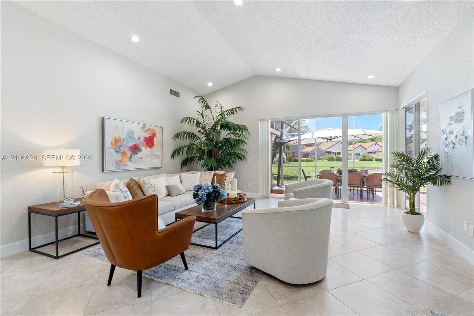 7259 Via Palomar, Boca Raton, FL 33433 Vaulted ceilings, neutral ceramic tile flooring, recessed lighting, and large sliding glass doors providing access to a screened patio