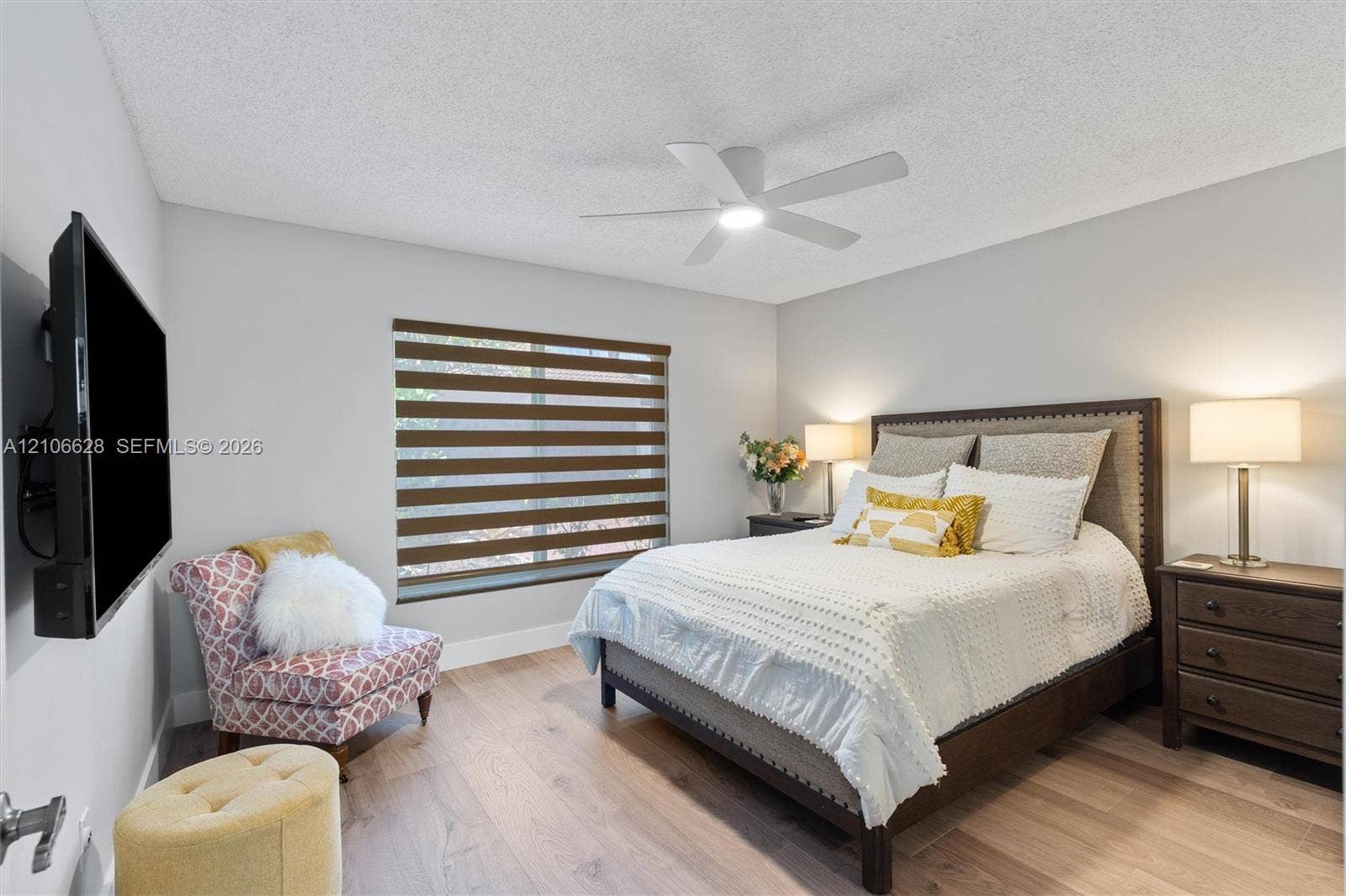 7259 Via Palomar, Boca Raton, FL 33433 Wood-finish flooring, ceiling fan with integrated lighting, and horizontal dual-layer privacy blinds
