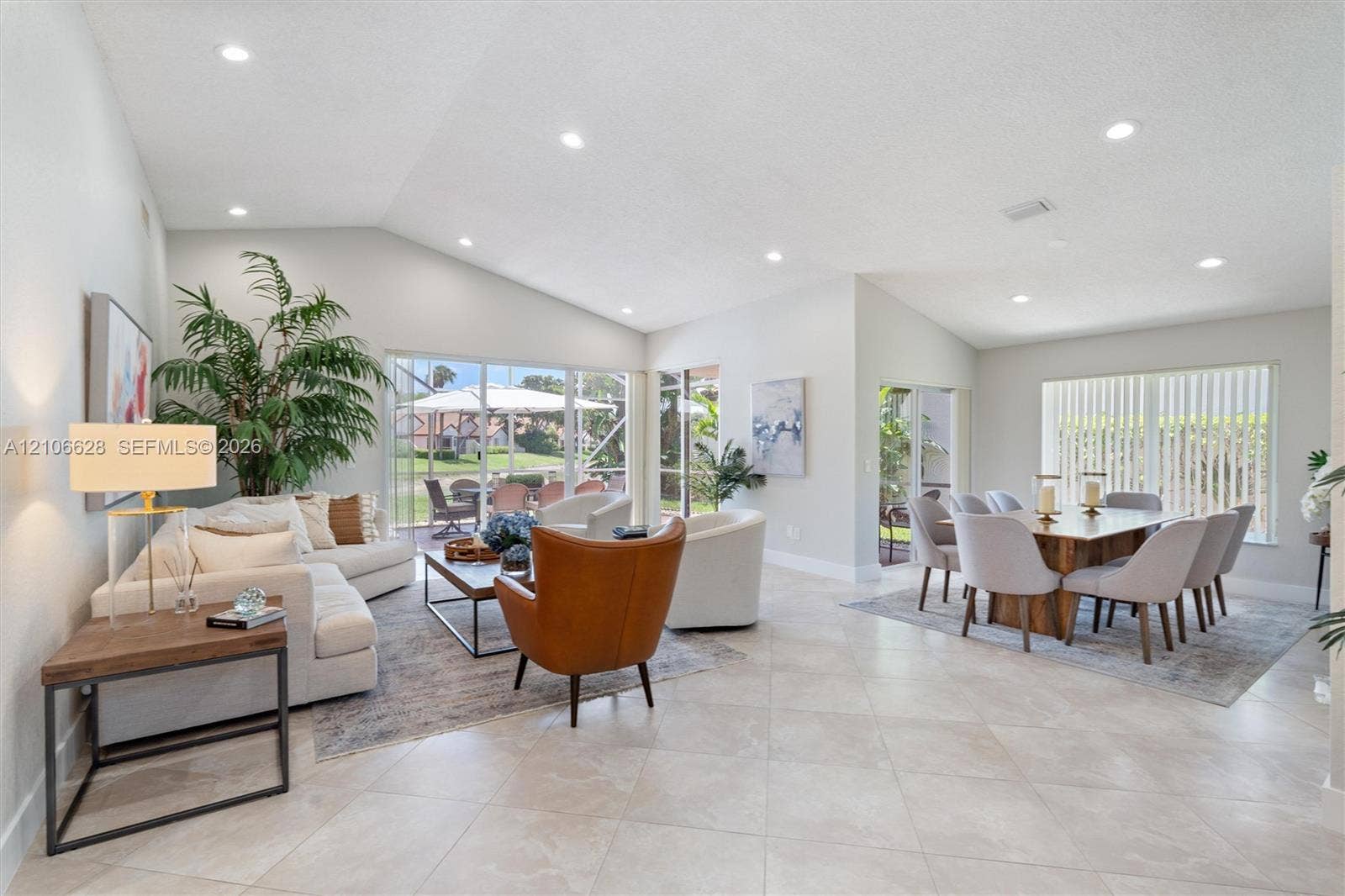 7259 Via Palomar, Boca Raton, FL 33433 Vaulted ceilings, neutral tile flooring, recessed lighting, and large sliding glass doors providing outdoor access