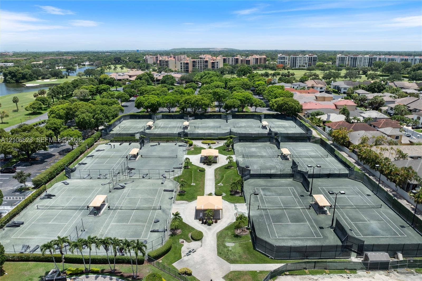 7259 Via Palomar, Boca Raton, FL 33433 Tennis complex featuring multiple hard-surface courts, perimeter fencing, overhead lighting, and centrally located gazebos