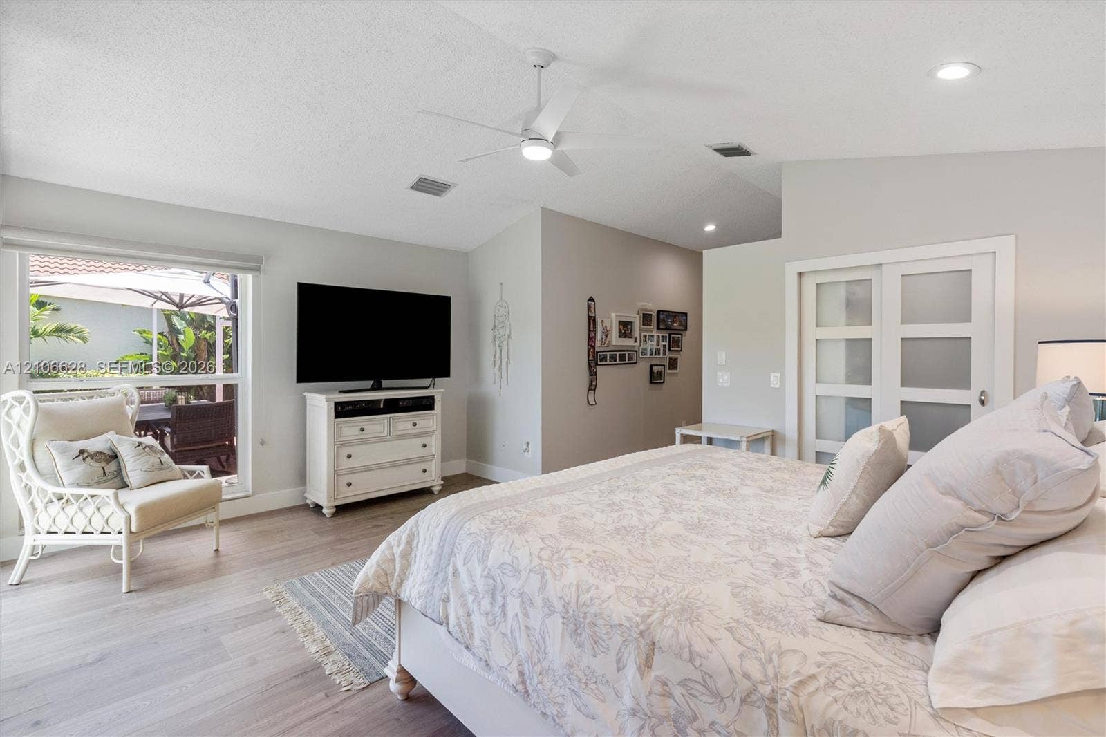 7259 Via Palomar, Boca Raton, FL 33433 Vaulted ceilings with a central fan, wood-finish flooring, and frosted-glass panel doors